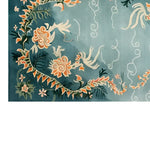 A beautifully crafted area rug with a vibrant floral design on a teal background, showcasing intricate patterns and vivid colors. This wool rug is ideal for adding a touch of elegance to living room spaces, especially in an 8x10 size.