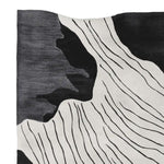Close-up view of the Slate Canyon Drift Hand Tufted Rug, featuring an abstract black and white design that adds a contemporary flair to any space. This wool area rug, perfect for living rooms, measures 8x10 and showcases intricate patterns ideal for modern interiors.
