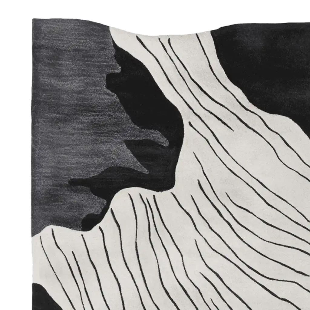 Close-up view of the Slate Canyon Drift Hand Tufted Rug, featuring an abstract black and white design that adds a contemporary flair to any space. This wool area rug, perfect for living rooms, measures 8x10 and showcases intricate patterns ideal for modern interiors.