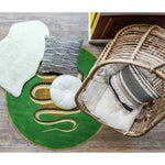 Top view of a vibrant green and gold round hand-tufted wool rug featuring a snake design, perfect for adding a touch of elegance to a dining room. The area rug complements the earthy tones of the surrounding decor, including a wicker chair and soft cushions, ideal for formal dining room settings.