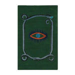 A striking green wool area rug featuring a unique design with a central red and blue eye motif, bordered by a snake pattern. This hand-tufted vintage rug is perfect for adding an artistic touch to your dining room, kitchen, or hallway. Ideal as a kitchen runner rug or bathroom runner rug, it complements formal dining room settings and adds warmth and style to any space.