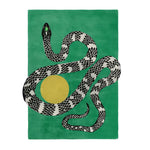 A contemporary wool rug featuring a striking design of a black and white snake intertwined with a yellow sun on a lush green background. Perfect for large living room spaces, this hand-tufted area rug adds a bold statement to any modern decor.
