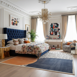 Luxurious bedroom with a large bed, colorful bedding, a contemporary hand-tufted wool rug, and decorative elements.