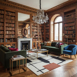 Luxurious living room with bookshelves, green sofa, blue armchair, a contemporary hand-tufted wool rug, and a chandelier.