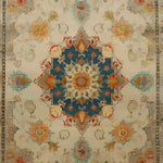 A beautifully detailed hand-knotted area rug featuring a rich floral design with a vintage Persian aesthetic. The central medallion is highlighted in deep blue and surrounded by intricate patterns in warm tones, perfect for enhancing any living room space. Ideal as an 8x10 living room rug, this floral rug adds elegance and charm to your home decor.