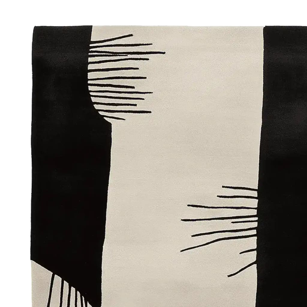 Close-up view of the Soft Ink Surge Hand Tufted Area Rug showcasing its bold, contemporary design with black and beige abstract patterns. This wool rug is perfect for adding a modern touch to large living rooms, especially as an 8x10 rug.