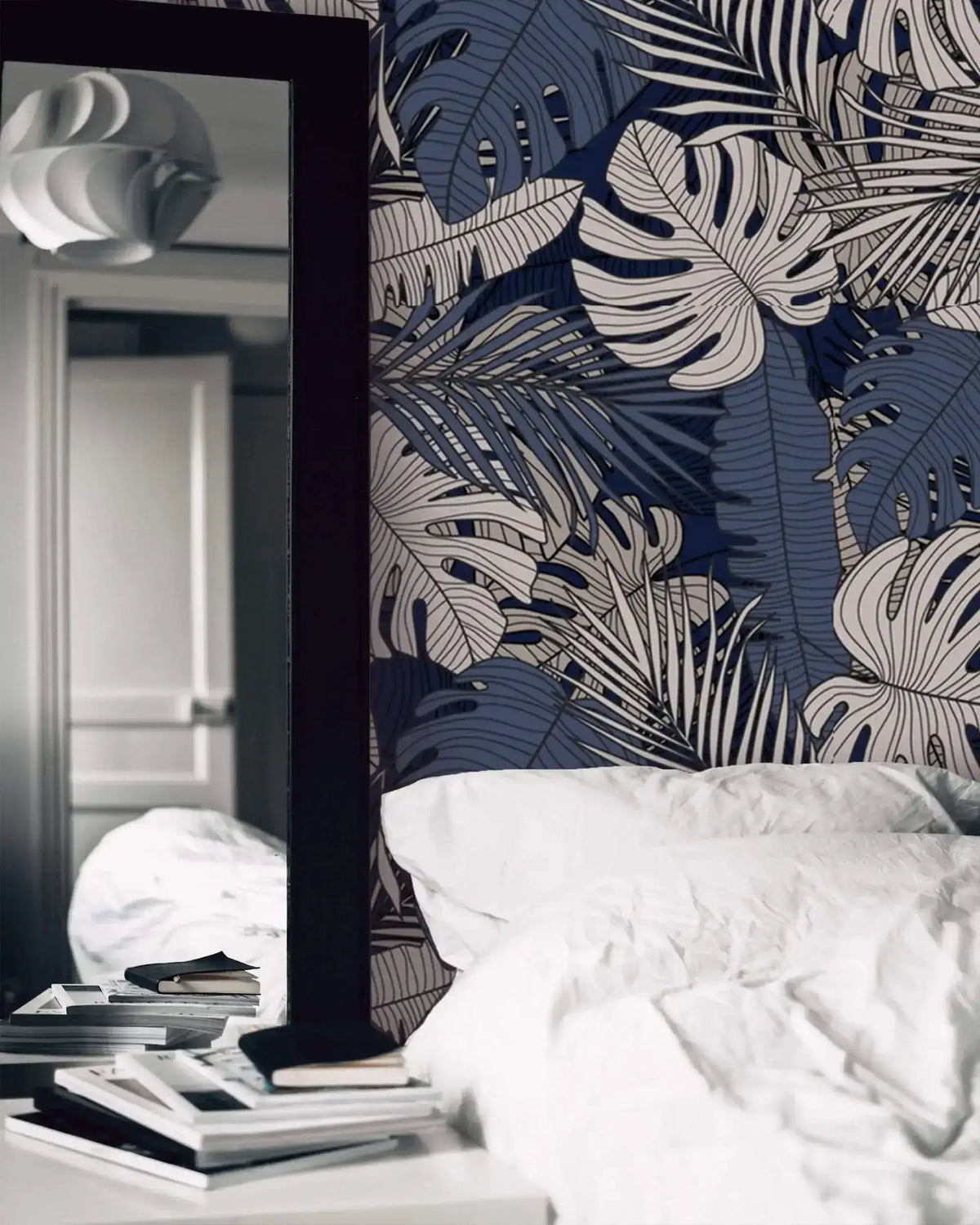 Soft pink blossoms and sage leaf wallpaper as bedroom feature wall behind white linen bedding and wood nightstand