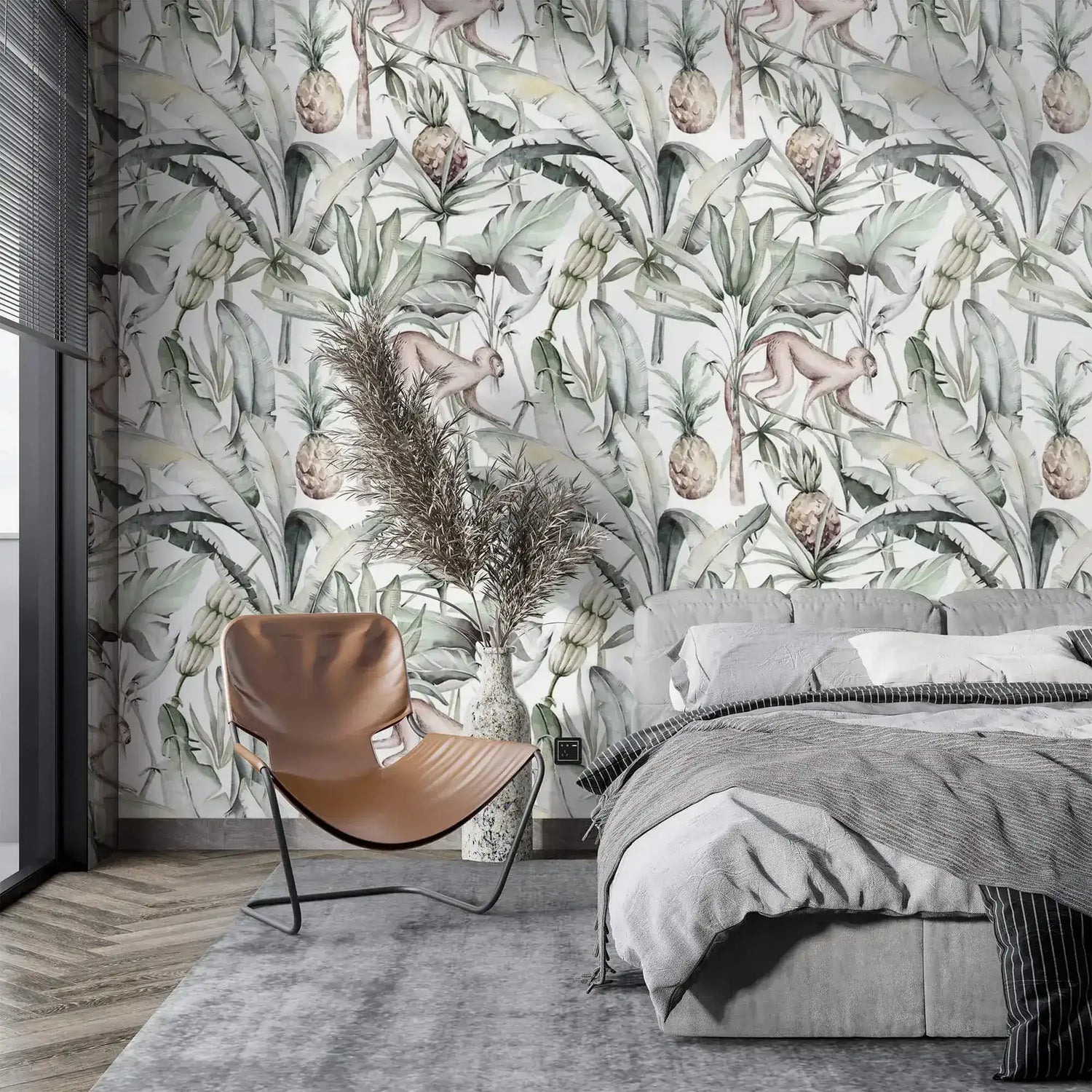Soft watercolor tropical jungle wallpaper with palms and pineapples in bedroom with tan chair and grey bed