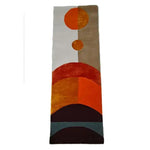 This vibrant Solar Eclipse Hand Tufted Wool Rug Runner features an abstract design with bold geometric patterns in shades of orange, brown, and beige. Perfect as an area rug for adding a touch of contemporary style to your kitchen, hallway, or living room. The wool rug showcases a unique artistic flair, ideal for those seeking distinctive kitchen runner rugs or bathroom runner rugs.