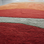 Close-up of Solar Eclipse runner pile, plush bands of deep red, sage grey and terracotta orange