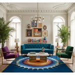 Modern living room with a blue sofa, colorful blue contemporary wool rug, and decorative elements.