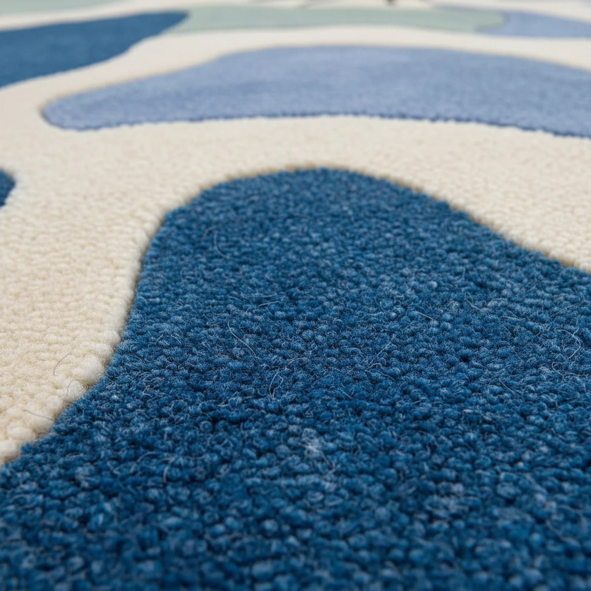 Close-up of a blue textured rug with abstract patterns