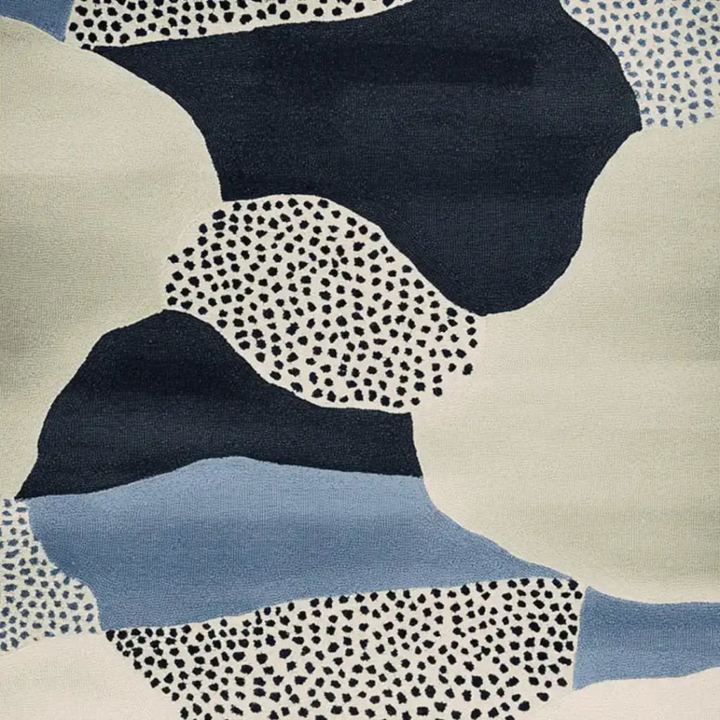 Close-up view of the Speckled Terrain Drift Hand Tufted Rug, showcasing its contemporary abstract design in shades of blue, black, and cream. This wool area rug features a unique speckled pattern, perfect for adding a modern touch to any living room.