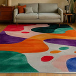 Vibrant Spectrum Shapes Hand Tufted Area Rug Runner in a modern living room setting. This contemporary wool rug features a dynamic abstract pattern with bold colors like orange, purple, and teal, perfect as a large living room rug or a stylish addition to any office or hallway.