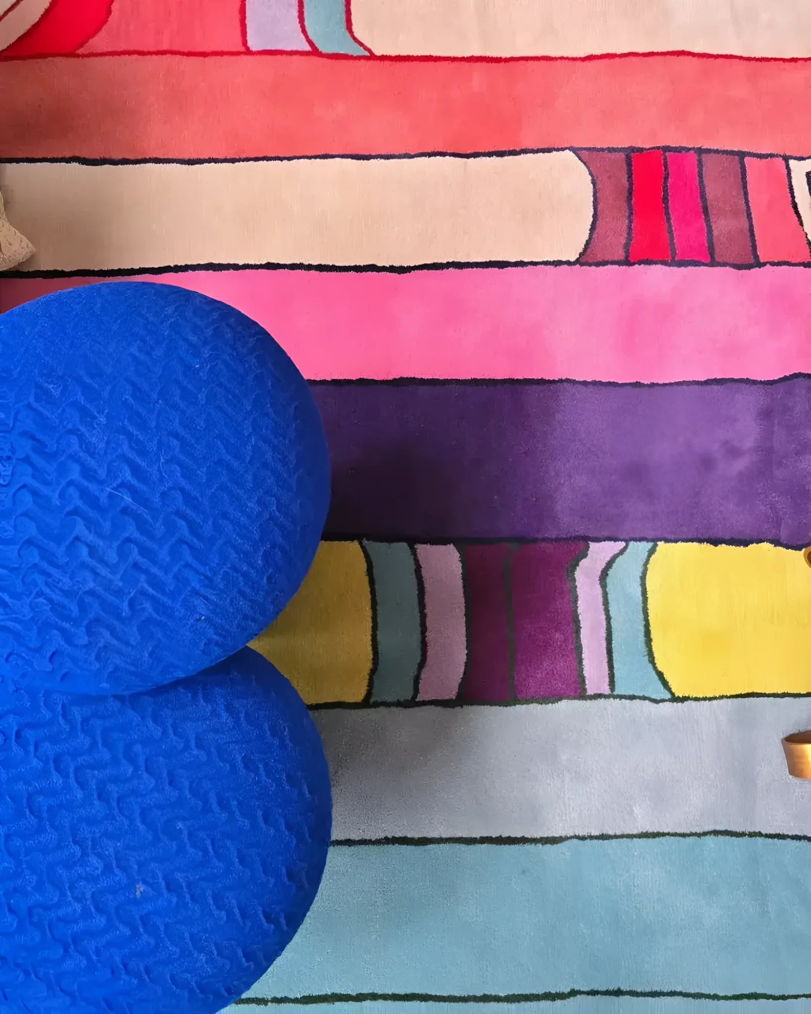 A vibrant Spectrum Stripe Hand Tufted Area Rug, ideal for large living rooms. This contemporary wool rug in an 8x10 size features bold, colorful stripes in shades of pink, purple, yellow, and blue, providing a lively touch to modern living room decor.