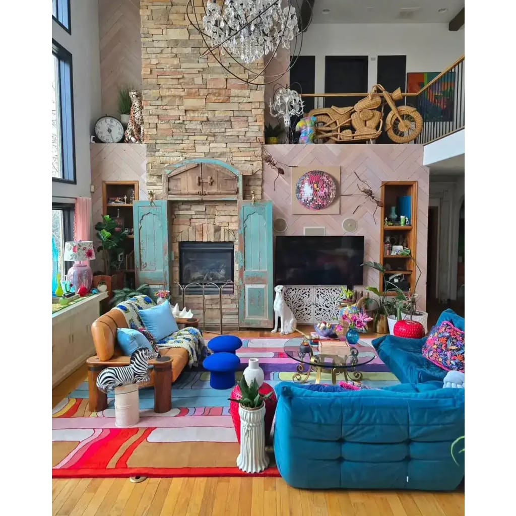 A vibrant Spectrum Stripe Hand Tufted Rug in a cozy living room setting. This contemporary wool area rug adds a splash of color with its bold, geometric pattern, making it an ideal choice for large living room rugs or those seeking living room rugs 8x10. The rug complements the eclectic decor, featuring a mix of modern and vintage elements, creating a warm and inviting atmosphere.