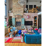 A vibrant Spectrum Stripe Hand Tufted Rug in a cozy living room setting. This contemporary wool area rug adds a splash of color with its bold, geometric pattern, making it an ideal choice for large living room rugs or those seeking living room rugs 8x10. The rug complements the eclectic decor, featuring a mix of modern and vintage elements, creating a warm and inviting atmosphere.