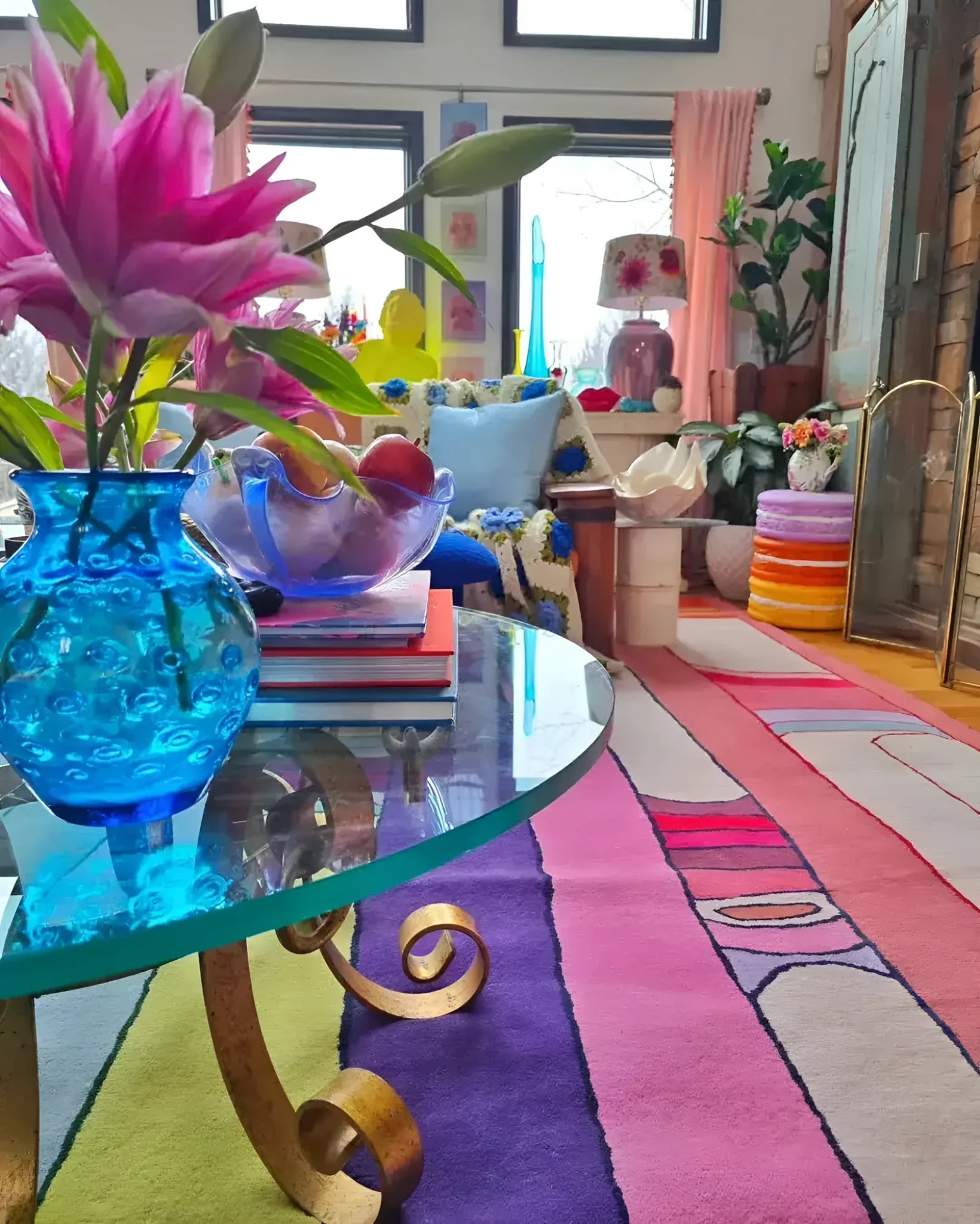 A vibrant Spectrum Stripe Hand Tufted Rug in a living room setting, showcasing its bold and colorful stripes. This contemporary wool rug adds a splash of color, complementing the eclectic decor with a glass coffee table and floral arrangements. Perfect for those seeking large living room rugs or an 8x10 area rug to enhance their space.