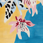 Close-up view of the Spotted Petal Paradise Hand Tufted Rug, showcasing a vibrant abstract floral design with pink, blue, and yellow hues. Perfect as a contemporary wool area rug for living room spaces, available in 8x10 size.