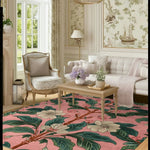 A stunning Spring Garden Petals Hand Tufted Area Rug featuring a vibrant floral design in shades of pink, green, and beige. This wool rug adds elegance to a spacious living room, complementing the classic furniture and soft lighting.