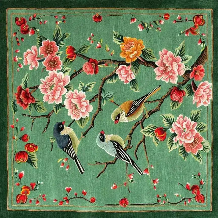 Springtime Serenade Hand Tufted Rug featuring an elegant design with birds perched on branches amidst colorful blossoms. This square wool rug, perfect for living rooms, combines vibrant pinks, yellows, and greens, adding a touch of nature to your decor. Ideal as a large area rug, it enhances any living space with its artistic and cozy appeal.