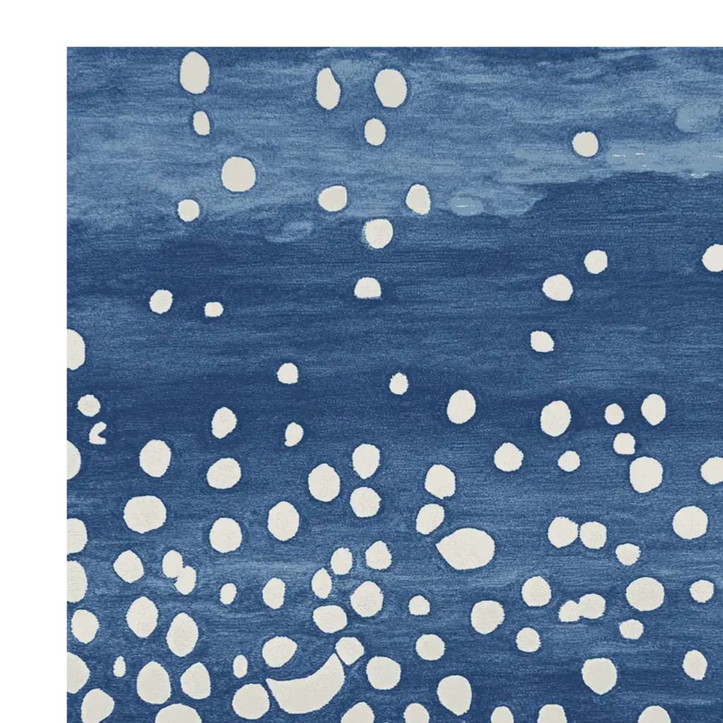 The Starfall in Indigo Hand Tufted Rug showcases a contemporary design with a deep indigo background speckled with white, abstract dots. This area rug, perfect for living rooms, combines modern aesthetics with the cozy texture of wool, making it a stylish and functional addition to any space. Ideal for those seeking an 8x10 living room rug that complements a variety of decor styles.