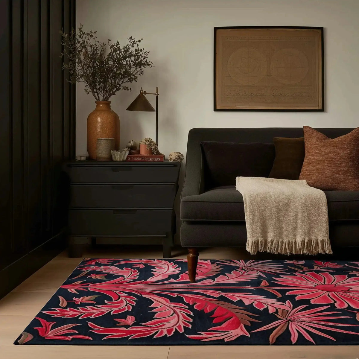 Pink garden rug edge by a charcoal sofa and side table, floor-level living room view
