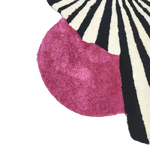 Close-up of a vibrant wool area rug, showcasing a striking design with bold black and white stripes alongside a rich pink section. Perfect for adding a touch of vintage charm to large living rooms, this hand-tufted rug is an ideal choice for those seeking stylish area rugs for their living space.