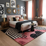 Modern bedroom with pink bed, decorative pillows, and a colorful rug.