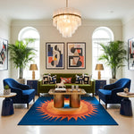 Modern living room with a colorful rug, blue chairs, and a green sofa.