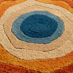 Close-up of a circular rug with concentric color rings.