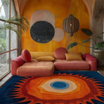 Orange sunburst rug grounding a boho room with terracotta sofa and warm-toned wall art