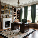 Grand office with dark wooden desk, bookshelf, and fireplace in a room with large windows and green curtains.