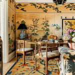 A beautifully designed living room showcases a Sunlit Sakura Hand Tufted Rug, perfectly complementing the elegant dining area. This wool floral rug features intricate sakura patterns, making it an ideal area rug for both the dining room and living room. The warm colors and floral motifs add a touch of sophistication to the dining table setting, creating a cozy and inviting atmosphere.