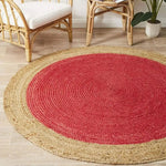A stylish area rug with a round design, featuring a vibrant red center surrounded by a natural jute border. Perfect for adding warmth to a dining room, this jute rug complements formal dining room settings with its earthy tones and elegant texture.