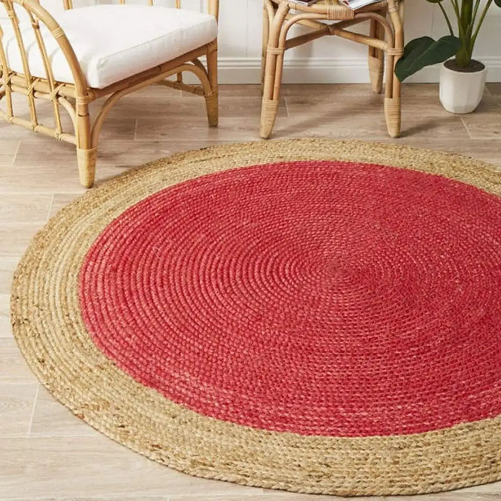A stylish area rug with a round design, featuring a vibrant red center surrounded by a natural jute border. Perfect for adding warmth to a dining room, this jute rug complements formal dining room settings with its earthy tones and elegant texture.