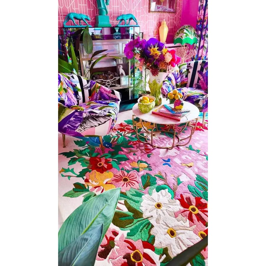 A vibrant living room featuring a Sunrise Bloom Hand Tufted Round Area Rug. This wool rug showcases a stunning floral design with colorful blooms, adding a burst of color to the living space. The round rug is perfectly placed under a chic coffee table, surrounded by stylish chairs, creating a cozy and inviting atmosphere. Ideal for those seeking large area rugs to enhance their living room decor.