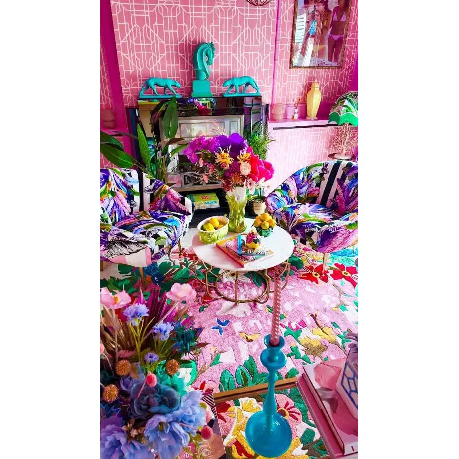 Vibrant living room featuring a Sunrise Bloom Hand Tufted Round Rug. This large area rug showcases a vivid floral pattern, perfect for adding color to any living space. The wool rug complements the colorful decor with its intricate design, making it an ideal choice for those seeking stylish rugs for living rooms.