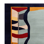 Close-up view of a contemporary wool area rug, showcasing its vibrant, surreal pattern with bold colors. Perfect for enhancing large living rooms, this hand-tufted design combines abstract shapes in red, yellow, blue, and gray, making it an eye-catching centerpiece for any modern space.