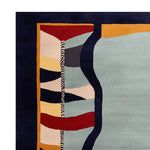 Close-up view of a contemporary wool area rug, showcasing its vibrant, surreal pattern with bold colors. Perfect for enhancing large living rooms, this hand-tufted design combines abstract shapes in red, yellow, blue, and gray, making it an eye-catching centerpiece for any modern space.