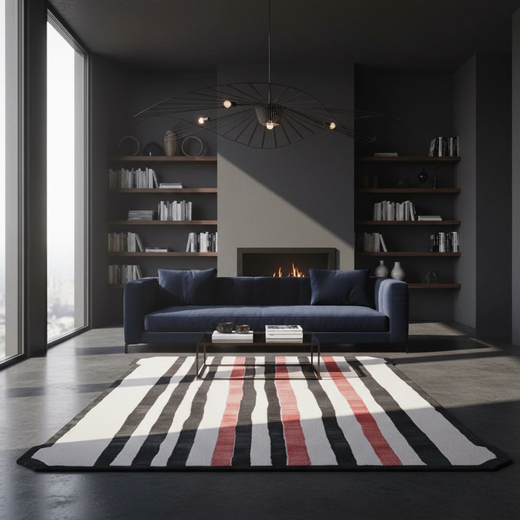 Modern living room with a blue sofa, striped rug, and bookshelves.