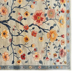 Beautiful Tangled Blossoms Knotted Wool Rug in an 8x10 size, perfect for living rooms. This area rug features a stunning floral design with vibrant orange, red, and yellow flowers against a subtle beige background, showcasing the intricate craftsmanship of a wool rug.