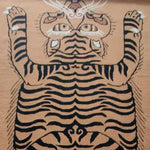 A close-up view of the Tanned Jungle Cat Hand Tufted Wool Rug, showcasing a striking abstract tiger design. This area rug, perfect for living rooms or as an 8x10 piece for bedrooms, features bold black stripes on a tan background, highlighting its luxurious wool texture.