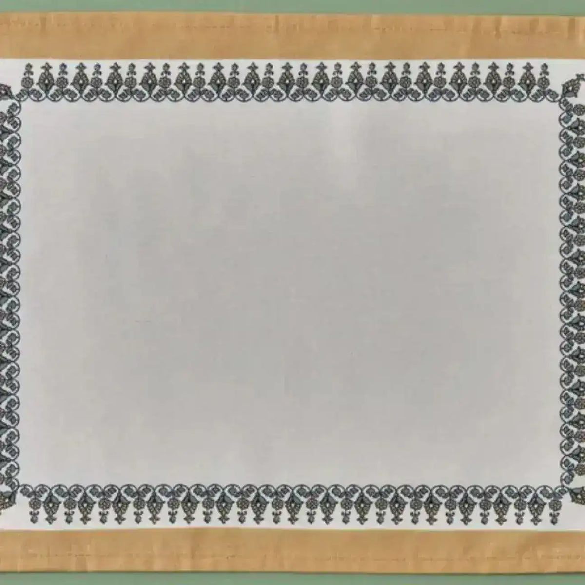 Tassel Trimmed placemat detail showing white linen center with black ornate border and gold fabric edge