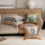 Colorful throw pillows with tassels arranged on a modern couch, featuring intricate designs and patterns.