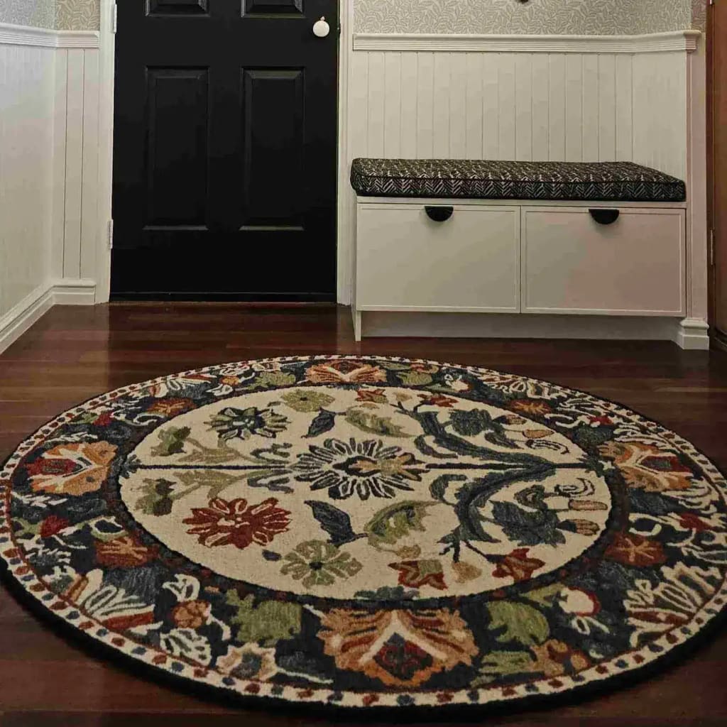 A beautifully crafted round area rug with a floral design, perfect for adding elegance to any dining room or living room space. This wool rug, known as 'The Blossom Grace Hand Tufted Round Rug,' features vibrant colors and intricate patterns, making it an ideal choice for dining room area rugs and dining room carpets.