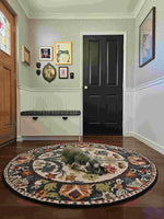 A beautifully designed Blossom Grace Hand Tufted Round Rug adds elegance to a cozy entryway. This floral area rug, perfect for both dining room area rugs and living room settings, features intricate patterns in vibrant colors, creating a warm and inviting atmosphere. A small dog rests comfortably on this wool rug, showcasing its plush texture and comfort.