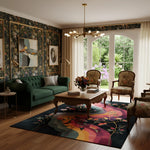 Living room with floral wallpaper, green sofa, and colorful rug.