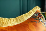 Close-up view of a decorative throw pillow featuring golden fringe and a vibrant animal print design, perfect for adding a touch of elegance to any space.