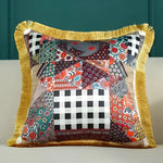 Colorful patchwork throw pillow with fringe detailing, perfect for adding a touch of style to any living space.